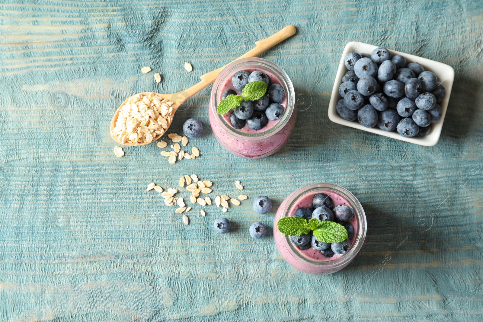 Photo of Flat lay composition with blueberry smoothie and space for text on wooden table