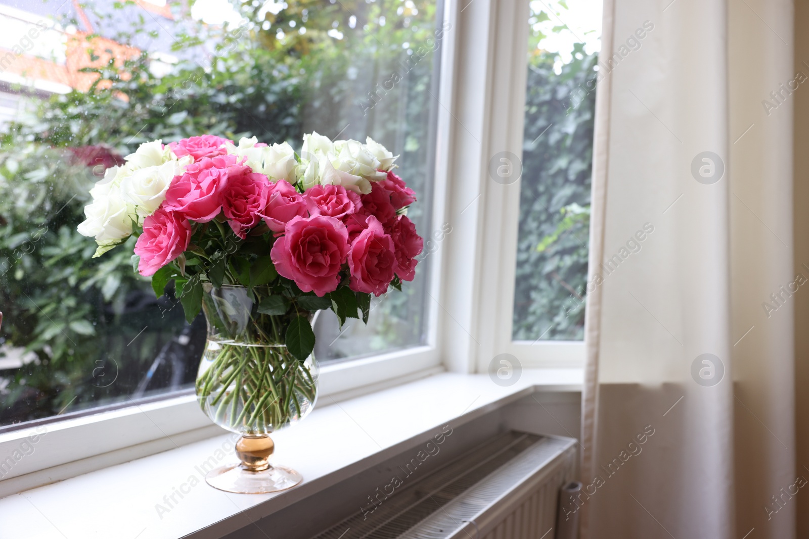 Photo of Vase with beautiful bouquet of roses on windowsill indoors, space for text