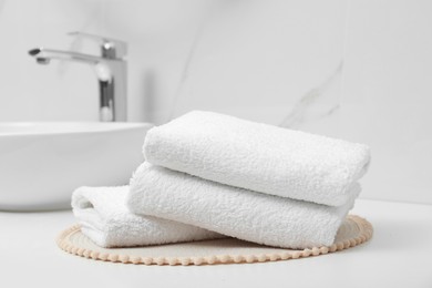 Folded bath towels on white table in bathroom