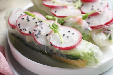 Photo of Delicious spring rolls wrapped in rice paper on table, closeup