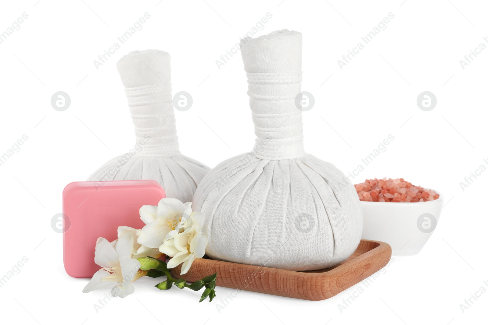 Photo of Herbal massage bags, soap, flowers and sea salt on white background. Spa procedure