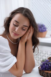 Photo of Portrait of beautiful young woman at table indoors