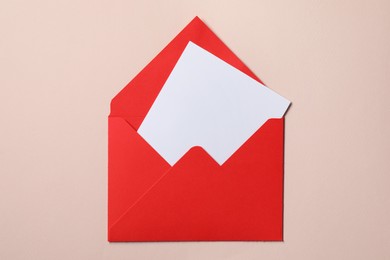 Photo of Letter envelope with card on beige background, top view