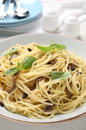 Photo of Delicious pasta with anchovies, olives and basil on plate