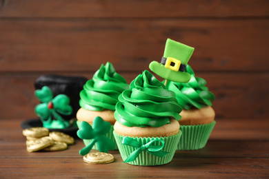 Decorated cupcakes and coins on wooden table. St. Patrick's Day celebration