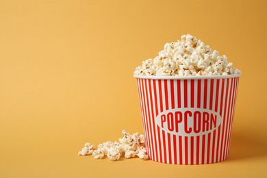 Photo of Delicious popcorn on yellow background. Space for text