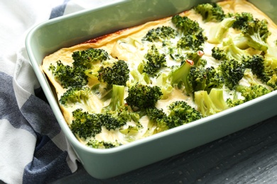 Photo of Tasty broccoli casserole in baking dish on table, closeup