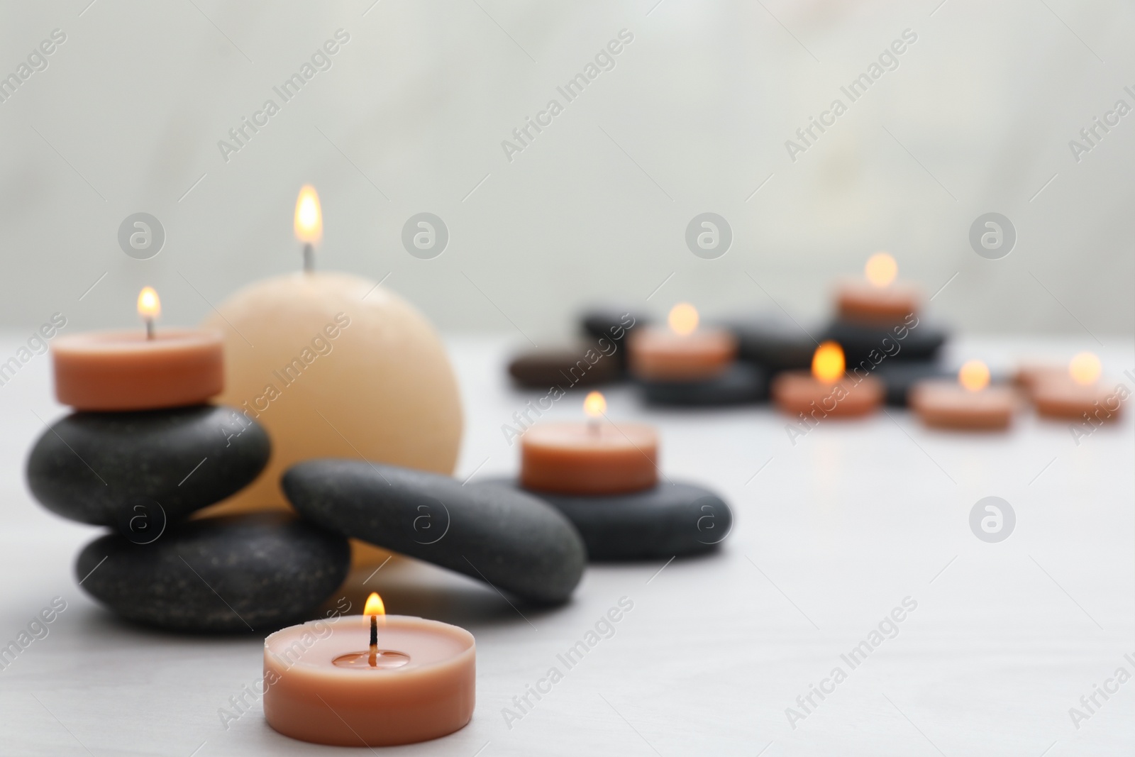 Photo of Composition with spa stones and candles on white table