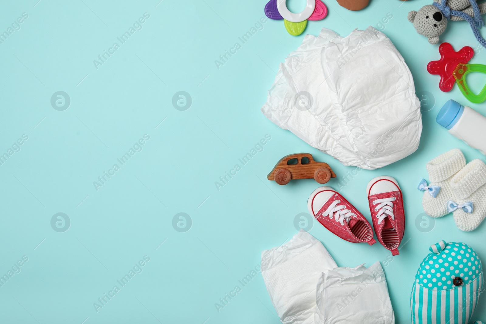Photo of Diapers and baby accessories on light blue background, flat lay. Space for text