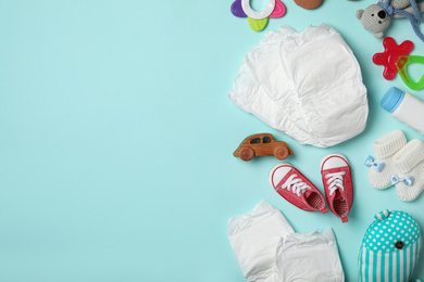 Diapers and baby accessories on light blue background, flat lay. Space for text