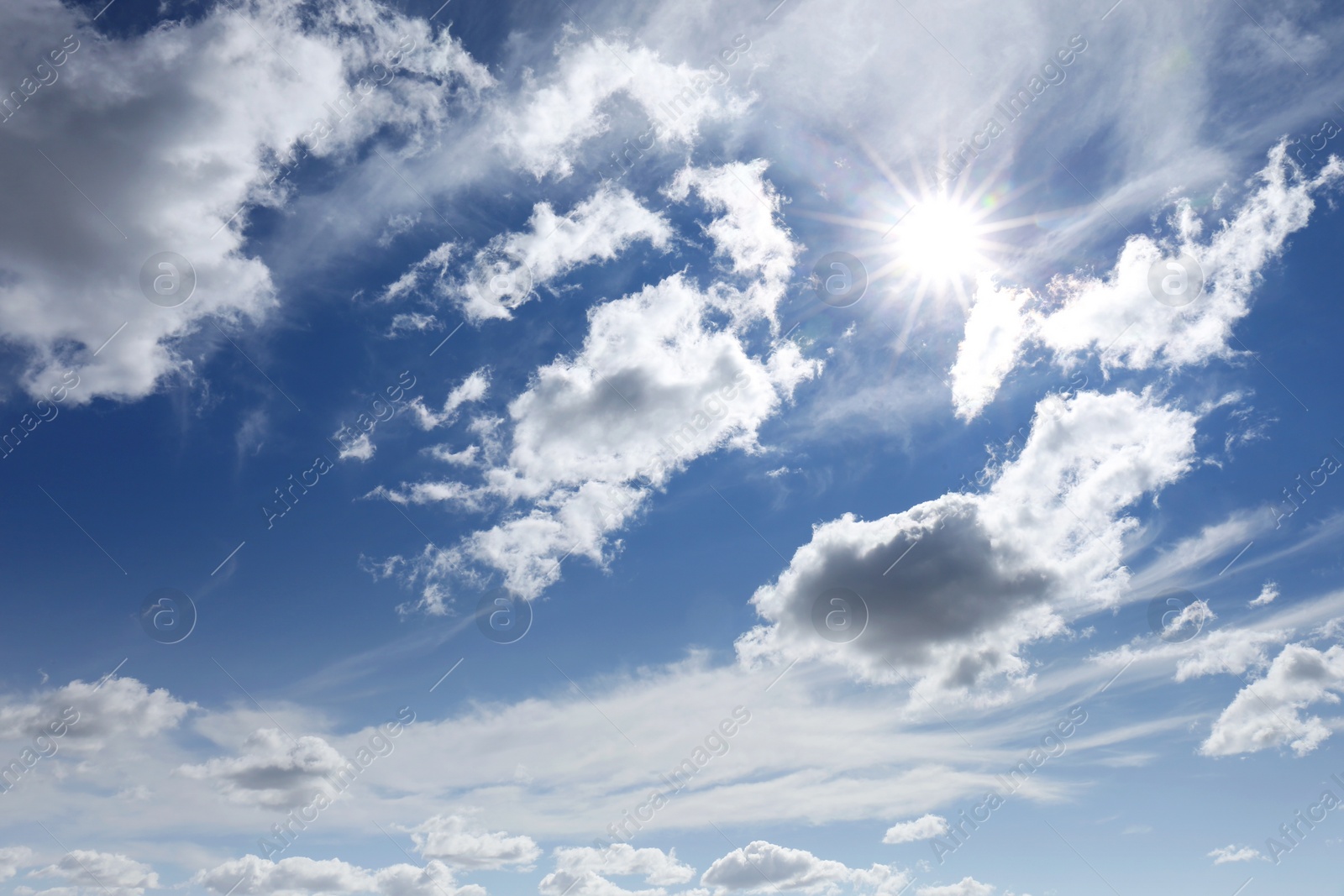 Photo of Picturesque blue sky with white clouds and bright sun