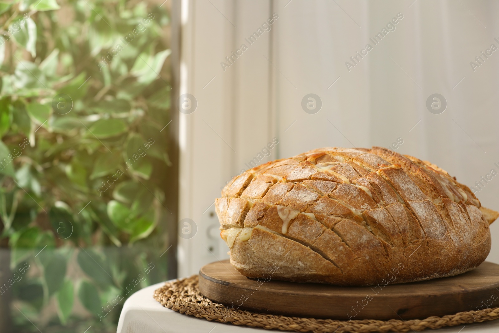 Photo of Freshly baked bread with tofu cheese on table indoors. Space for text