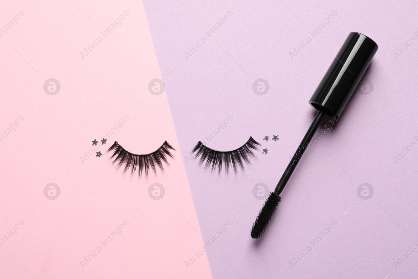 Photo of False eyelashes and mascara on color background, flat lay