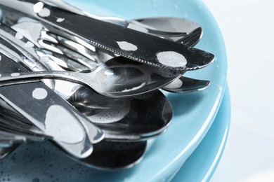 Photo of Different silverware in foam on plates, closeup