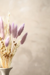 Photo of Dried flowers in vase against light grey background