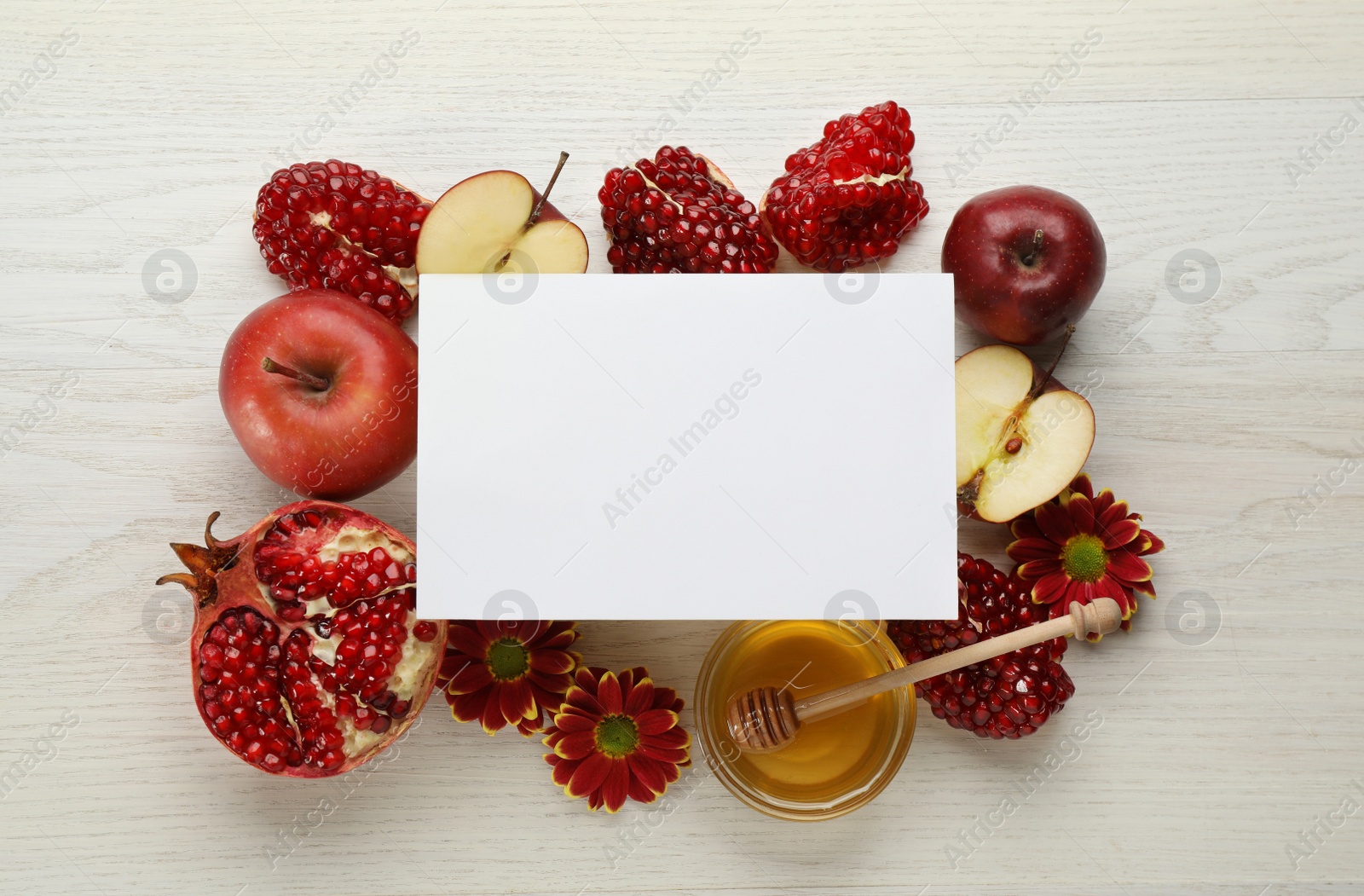 Photo of Flat lay composition with Rosh Hashanah holiday attributes and card on white wooden table. Space for text