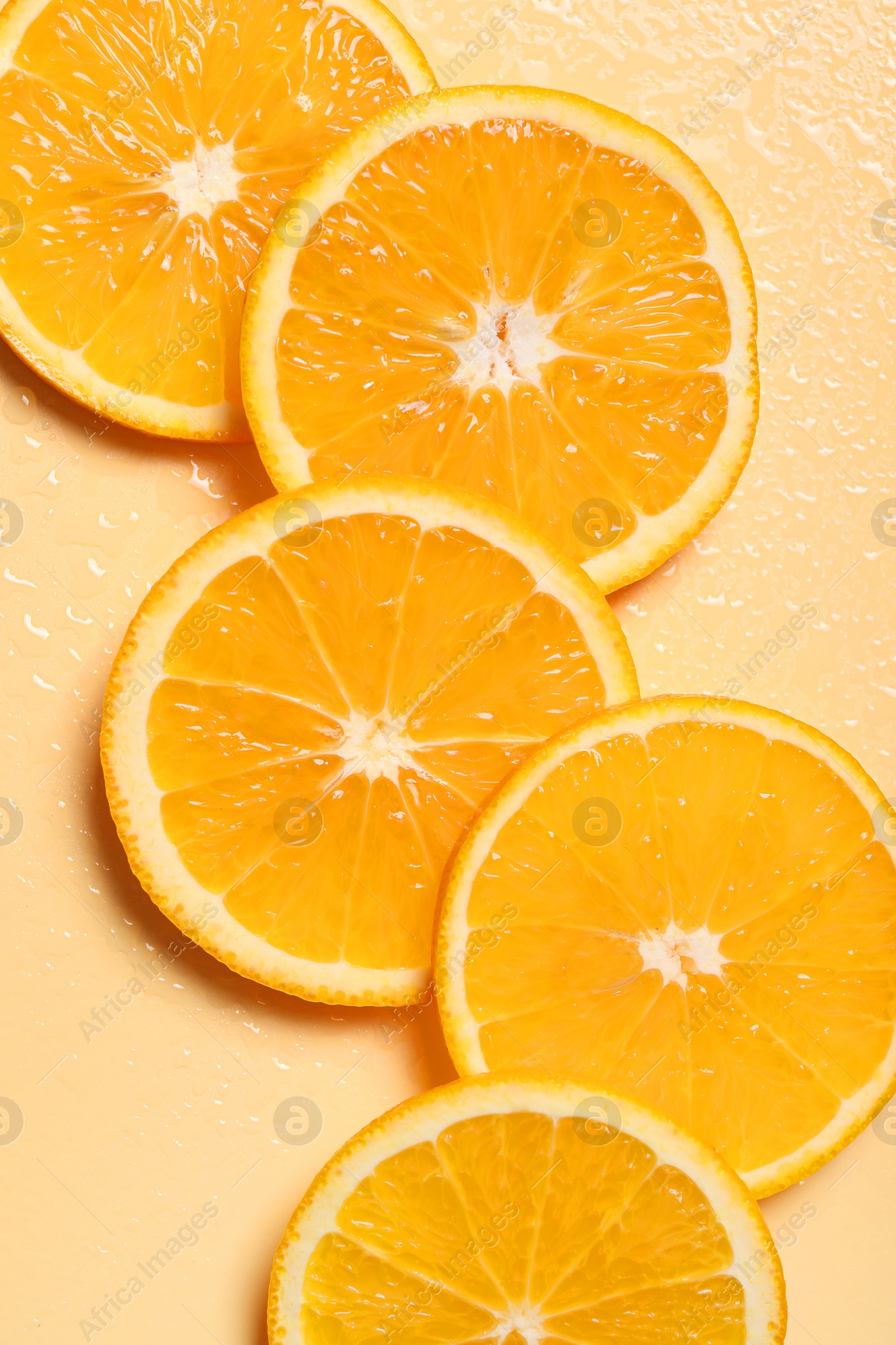 Photo of Slices of juicy orange on beige background, flat lay