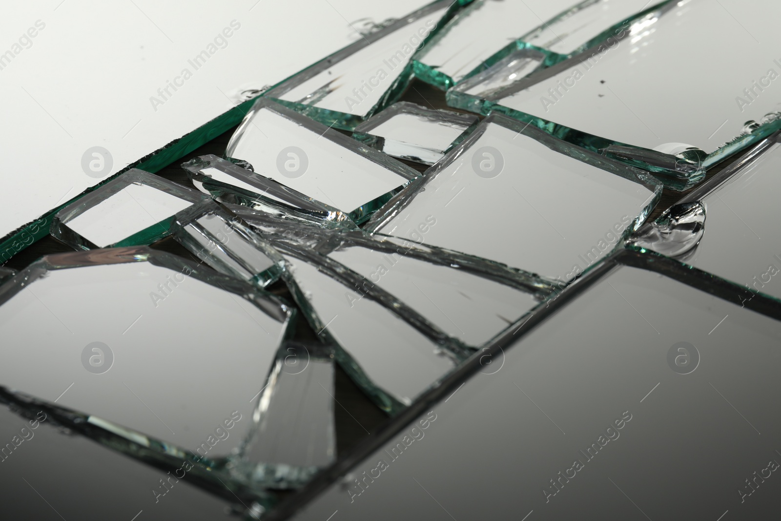 Photo of Shards of broken mirror on backing board, closeup