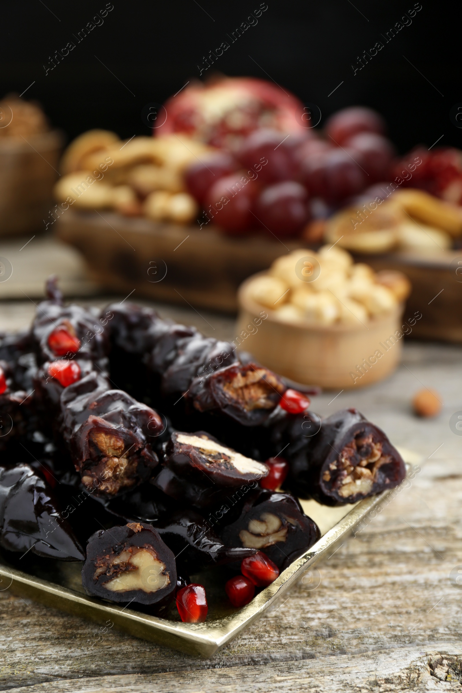 Photo of Tray with delicious sweet churchkhelas on wooden table, closeup