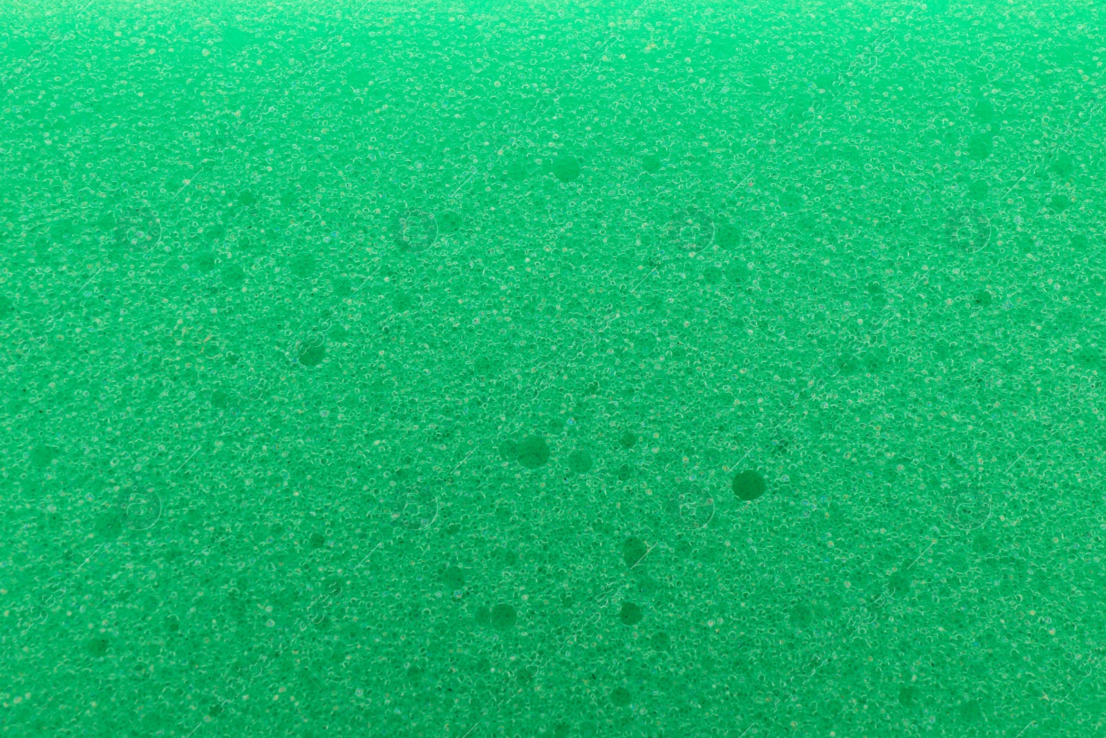 Photo of Green cleaning sponge as background, top view