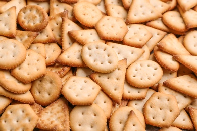 Many delicious crackers as background, closeup view