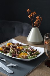 Photo of Delicious salad with beef tongue, orange and onion served on wooden table