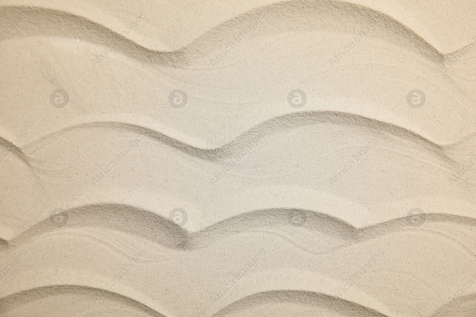 Photo of Waves made on sand as background, top view