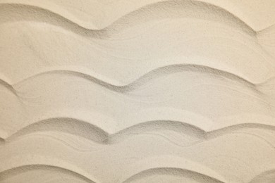 Photo of Waves made on sand as background, top view