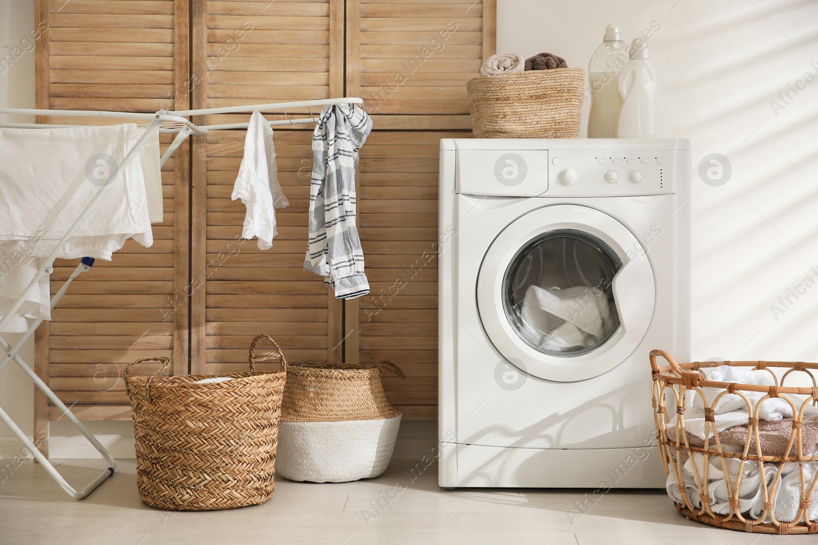 Photo of Modern washing machine in laundry room interior