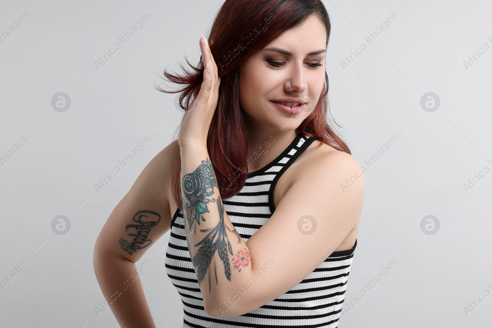 Photo of Portrait of beautiful tattooed woman on gray background