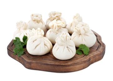 Photo of Wooden board with uncooked khinkali (dumplings) and parsley isolated on white. Georgian cuisine