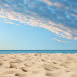Image of Sandy beach near sea under blue sky with clouds