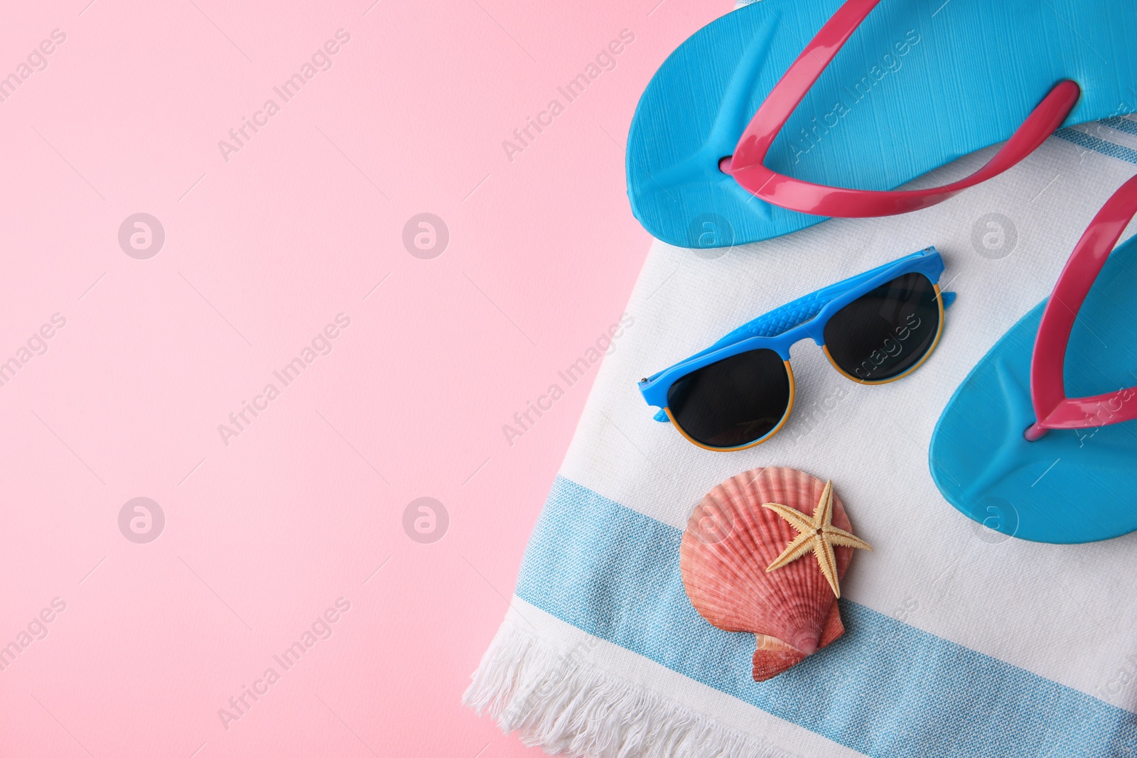 Photo of Flat lay composition with beach accessories on pink background, space for text