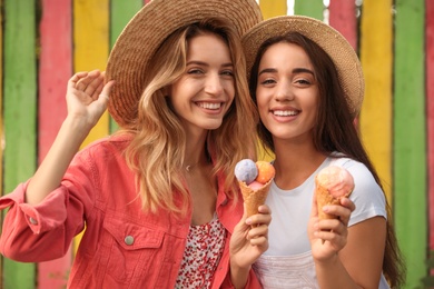 Young women with ice cream spending time together outdoors