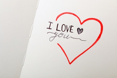 Phrase I Love You and heart drawings on notebook page