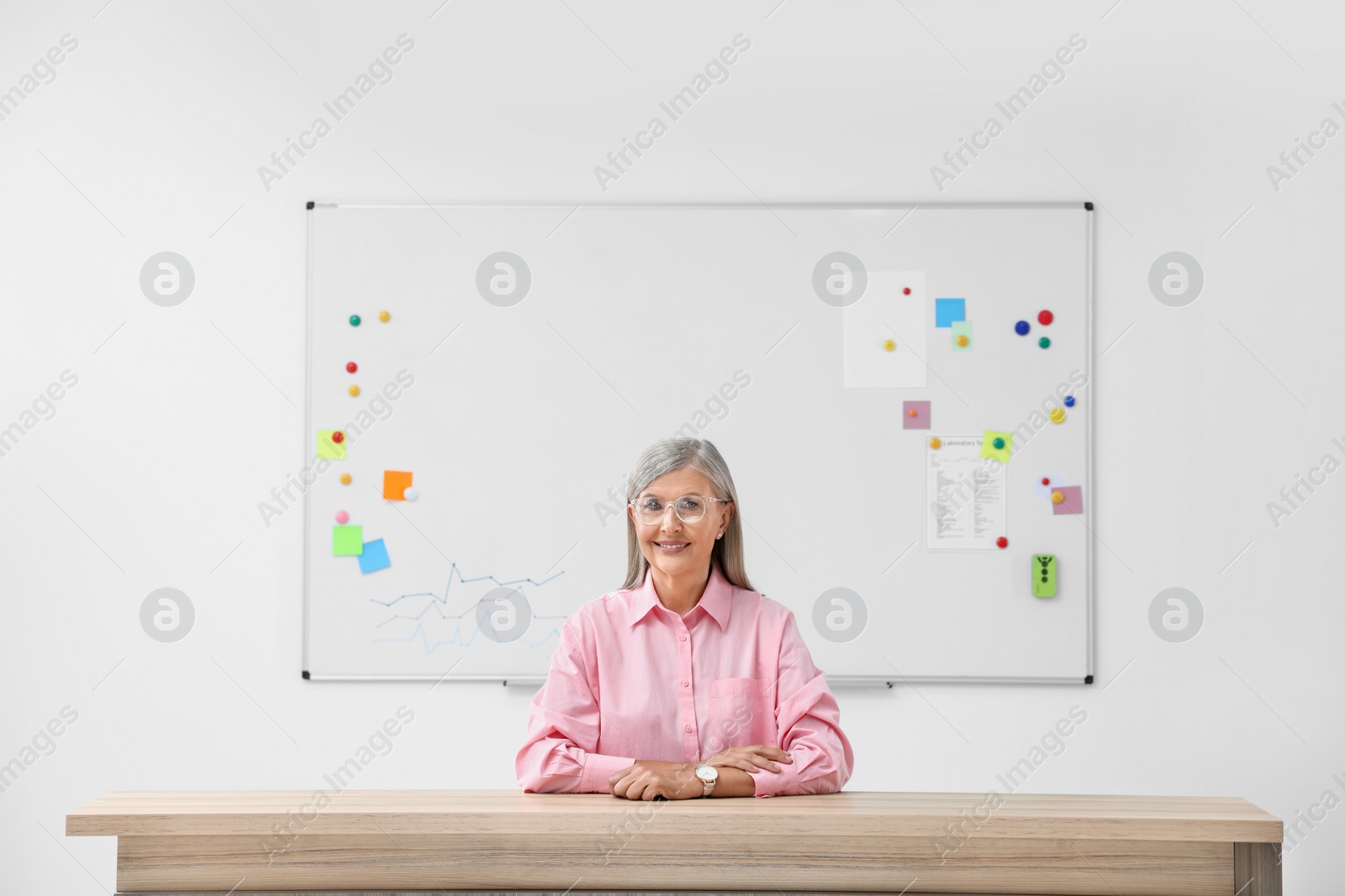 Photo of Portrait of professor sitting at desk in classroom