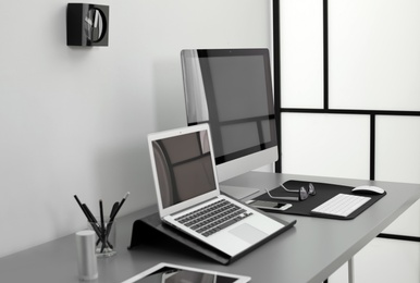 Modern workplace interior with computers on table. Space for text