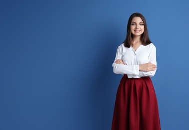 Portrait of young woman in stylish outfit on color background