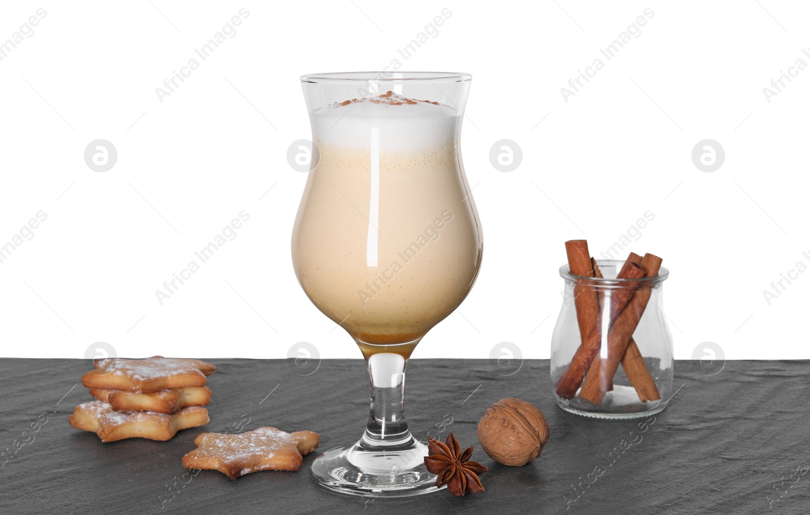 Photo of Delicious eggnog in glass, cookies and spices on grey table against white background