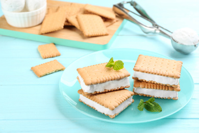 Sweet delicious ice cream cookie sandwiches on light blue wooden table