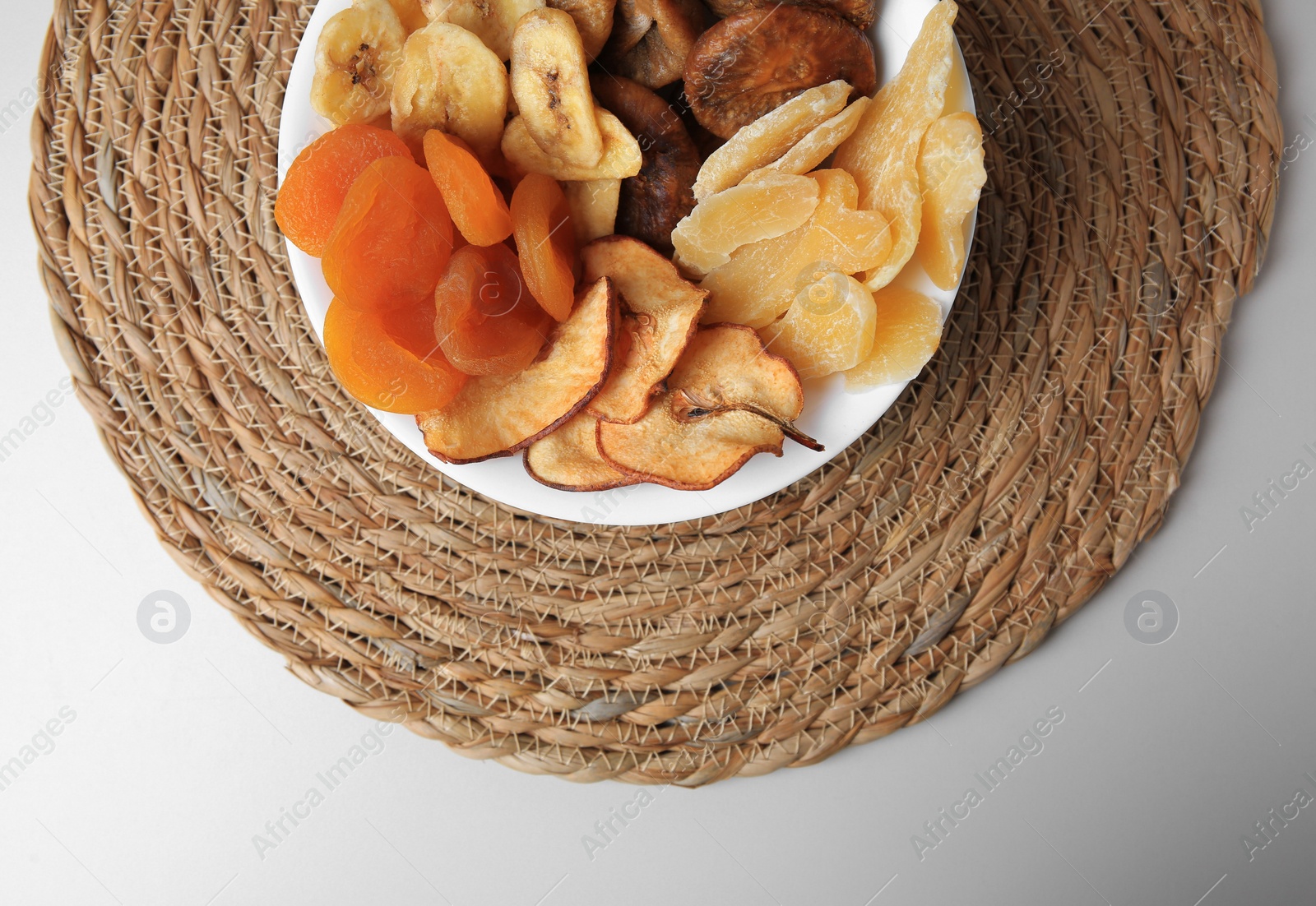 Photo of Bowl with different dried fruits on white background, top view