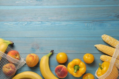 Fresh fruits and vegetables on light blue wooden table, flat lay. Space for text