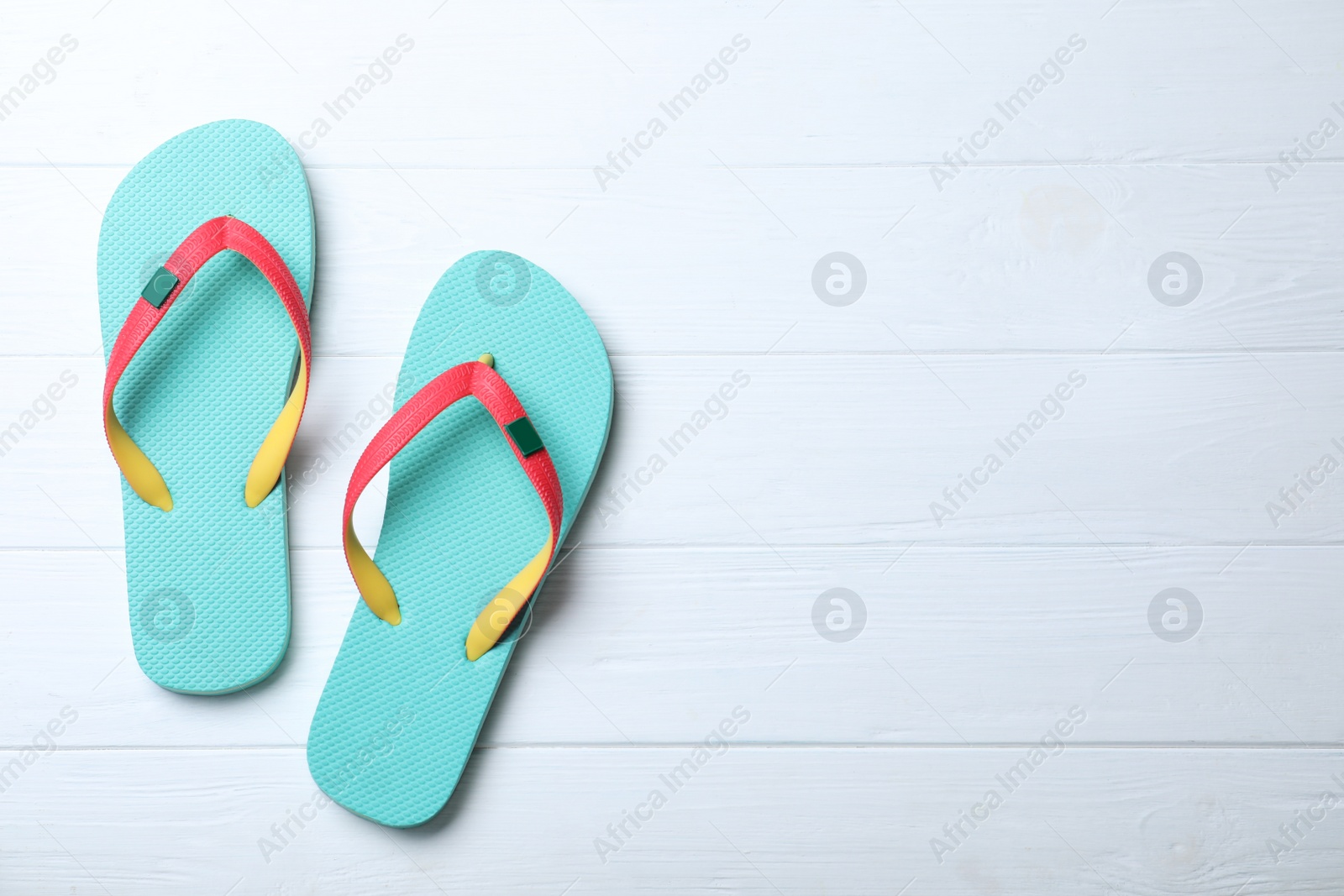 Photo of Stylish flip flops on white wooden background, flat lay. Space for text