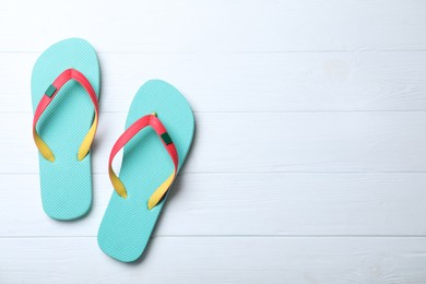 Photo of Stylish flip flops on white wooden background, flat lay. Space for text