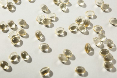 Photo of Many vitamin capsules on light background, closeup