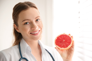 Photo of Nutritionist with grapefruit near window in office