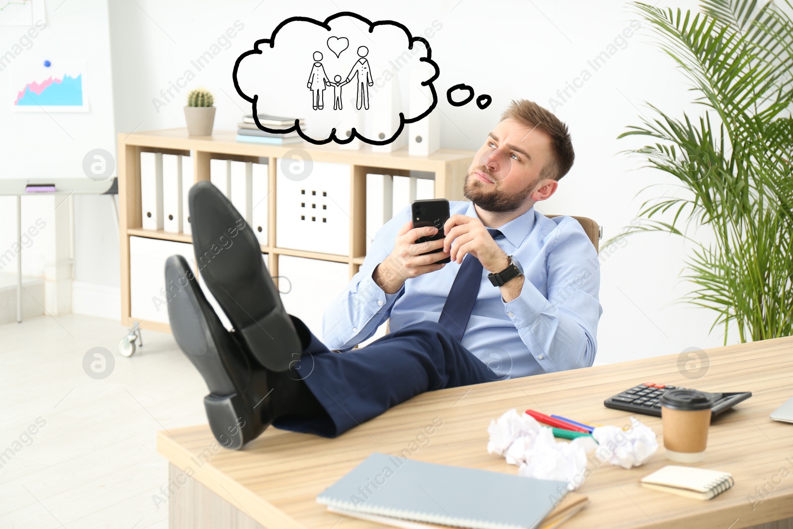Image of Businessman dreaming about family in office. Concept of balance between life and work