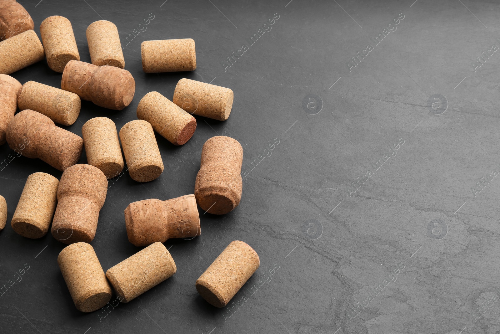 Photo of Wine bottle corks on black table. Space for text