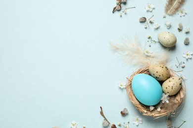 Photo of Beautiful flat lay composition with flowers and Easter eggs on light background. Space for text