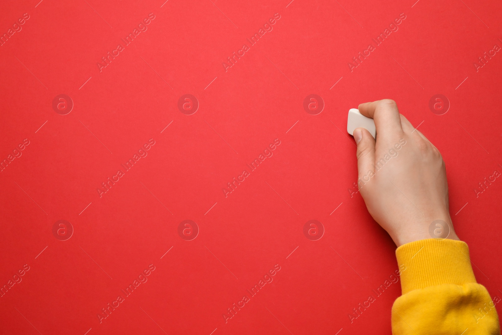 Photo of Man erasing something on red background, closeup. Space for text